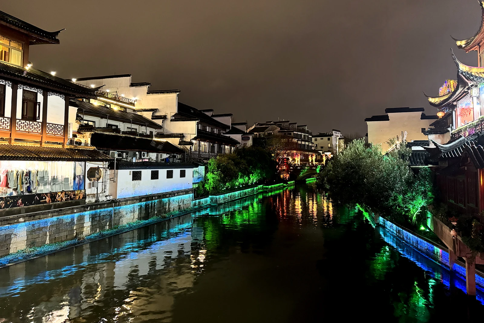 Traditional riverside buildings and bright reflections on the Qinhuai River at night in Nanjing