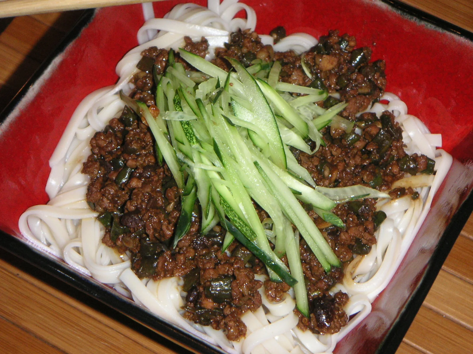 Wheat noodles topped with dark bean sauce and shredded cucumber